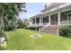 Home exterior featuring a screened porch overlooking a lush backyard with a decorative water feature at 401 Ralston Creek St, Charleston, SC 29492