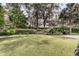 Green backyard featuring a bench, well-manicured lawn and mature landscaping at 401 Ralston Creek St, Charleston, SC 29492