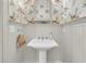 Well-lit powder room featuring stylish wallpaper, pedestal sink and a decorative mirror at 401 Ralston Creek St, Charleston, SC 29492