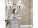 Traditional half bath with marble top vanity, round mirror, and decorative sconces at 401 Ralston Creek St, Charleston, SC 29492