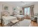 Serene bedroom featuring twin beds, soft hues, and a comfortable sitting area for relaxation at 401 Ralston Creek St, Charleston, SC 29492