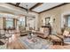 A traditionally styled living room with exposed wood beams and hardwood flooring flowing into the adjacent kitchen at 401 Ralston Creek St, Charleston, SC 29492