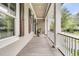 Lovely covered porch with white columns and railings overlooking a well-manicured neighborhood street at 401 Ralston Creek St, Charleston, SC 29492