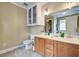 Bright bathroom with double sinks, wood cabinets, and a large mirror with modern lighting at 419 Equinox Cir, Ladson, SC 29456