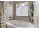 Relaxing bathroom boasts a soaking tub, tiled walls, and a window offering ample natural light at 419 Equinox Cir, Ladson, SC 29456