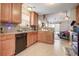 Well-appointed kitchen features wood cabinets, tile backsplash, and a view into the cozy living room at 419 Equinox Cir, Ladson, SC 29456