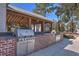 Community outdoor kitchen with stainless steel gas grills and brick counter under covered structure at 420 Oak View Way, Summerville, SC 29483