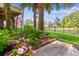 Beautiful backyard with lush landscaping, palm trees, and a peaceful pond at 5394 Clairmont Ln, North Charleston, SC 29420