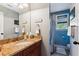 Stylish bathroom with cherry cabinets, granite counters, and a large framed mirror at 5394 Clairmont Ln, North Charleston, SC 29420