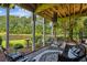 Relaxing covered patio with ample seating, a swing, a ceiling fan and a view of the backyard and lake at 5394 Clairmont Ln, North Charleston, SC 29420