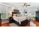 Comfortable bedroom with a dark wood bed, ceiling fan, and plantation shutters at 5394 Clairmont Ln, North Charleston, SC 29420