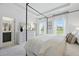 Bright main bedroom featuring a four-poster bed, large windows, and neutral decor at 540 Scholar Way, Summerville, SC 29486