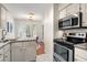 Clean kitchen boasts granite countertops, stainless steel appliances, and white cabinets at 5558 Green Dolphin Way, Kiawah Island, SC 29455