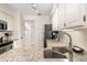 Bright kitchen featuring granite countertops, a stainless steel sink, and ample storage space at 5558 Green Dolphin Way, Kiawah Island, SC 29455