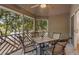 Relaxing screened porch featuring a tile-top table with seating for four surrounded by wooded scenery at 5558 Green Dolphin Way, Kiawah Island, SC 29455
