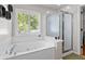 Primary bathroom features a large garden tub with jets, glass enclosed shower, and plantation shutters at 578 Delafield Dr, Summerville, SC 29483