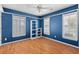 A modern bedroom features bright blue walls, a ceiling fan, and a window with wood shutters at 578 Delafield Dr, Summerville, SC 29483