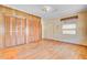 Bedroom featuring hardwood floors, a window with blinds, wainscoting, and double closet doors at 6 Dewey St, Charleston, SC 29403