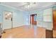 Bright living room with hardwood floors, white-painted wainscoting, and French doors to an adjacent room at 6 Dewey St, Charleston, SC 29403