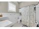 Charming bathroom features black and white tile, wainscoting and a shower and tub with curtain at 68 Vanderhorst St # A, Charleston, SC 29403