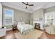Bright bedroom boasts wood floors, fireplace, and abundant natural light from large windows at 68 Vanderhorst St # A, Charleston, SC 29403