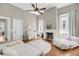 Cozy bedroom with white walls, wood floors, fireplace, ceiling fan, and natural light at 68 Vanderhorst St # A, Charleston, SC 29403