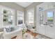 Cozy sunroom featuring bright windows, white couch, and access to spiral staircase at 68 Vanderhorst St # A, Charleston, SC 29403