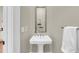Stylish powder room with pedestal sink, large mirror, and neutral color scheme at 68 Vanderhorst St # A, Charleston, SC 29403