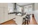 Modern kitchen with stainless steel appliances, including bar seating, granite countertops, and hardwood floors at 68 Vanderhorst St # B, Charleston, SC 29403