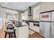 Open kitchen with stainless steel appliances, counter seating, and views into the adjacent dining area at 68 Vanderhorst St # B, Charleston, SC 29403