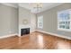 Living room with decorative fireplace, hardwood floors and natural light from windows at 68 Vanderhorst St # B, Charleston, SC 29403