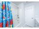 Clean, bright bathroom featuring a shower/tub combo with playful curtain and white door at 6976 Pumpkinseed Dr, Johns Island, SC 29455