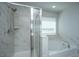 Elegant bathroom featuring a glass enclosed shower and a large soaking tub at 6976 Pumpkinseed Dr, Johns Island, SC 29455