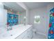 Well-lit bathroom featuring a double sink vanity, framed mirror, and shower with cute curtain at 6976 Pumpkinseed Dr, Johns Island, SC 29455