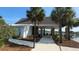 Exterior view of the community clubhouse with walkway, covered seating, and palm trees at 6976 Pumpkinseed Dr, Johns Island, SC 29455