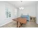 Dining room boasts wood floors, natural light from large windows, and blue accent furniture at 6976 Pumpkinseed Dr, Johns Island, SC 29455