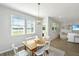 Bright dining space with views, wood table and stylish light fixture, open to the living room at 6976 Pumpkinseed Dr, Johns Island, SC 29455