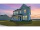 Two-story home with a manicured lawn, covered porch, and traditional architectural details at dusk at 6976 Pumpkinseed Dr, Johns Island, SC 29455