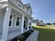 Inviting front porch with classic white columns and manicured landscaping by the front door at 6976 Pumpkinseed Dr, Johns Island, SC 29455