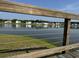 View of a pond with a wooden railing in the foreground, offering a peaceful outdoor setting at 6976 Pumpkinseed Dr, Johns Island, SC 29455