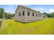 Exterior side view of the house, showing the siding, crawlspace vents, and the large backyard at 708 Tierra Loop, Summerville, SC 29483