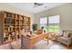 Bright home office with a large wood desk, chair, and bookcase filled with books and decor against hardwood floors at 708 Tierra Loop, Summerville, SC 29483