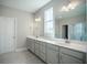 Modern bathroom featuring double sinks, quartz countertops, and large mirrors at 713 Breakers Reef Ln, Huger, SC 29450