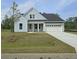 Charming blue two-story home with a well-manicured lawn, attached garage, and classic architectural details at 713 Breakers Reef Ln, Huger, SC 29450
