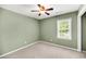 Cozy carpeted bedroom featuring a ceiling fan, window with blinds, and light green walls at 721 Lake Frances Dr, Charleston, SC 29412