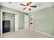 Comfortable bedroom with neutral carpet, green walls, ceiling fan, and walk-in closet with shelving at 721 Lake Frances Dr, Charleston, SC 29412