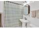 Bright bathroom featuring a pedestal sink, a large mirror, and a tiled shower with curtain at 727 Savannah Hwy, Charleston, SC 29407