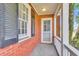 Cozy covered brick patio with painted trim and a door with vintage windows at 727 Savannah Hwy, Charleston, SC 29407