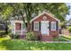 Charming brick home features a well-maintained lawn and a cozy, covered front porch at 727 Savannah Hwy, Charleston, SC 29407