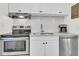 Bright kitchen featuring white cabinets, stainless steel appliances, and mosaic tile backsplash at 727 Savannah Hwy, Charleston, SC 29407
